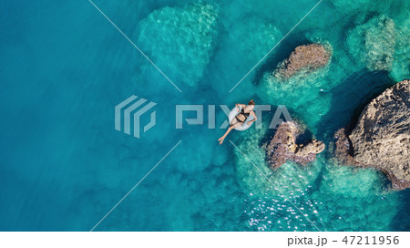 Aerial view at the girl on sea surface. Aerial view at the girl on sea surface. 47211956