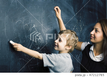 little cute boy in glasses with young real teacher, classroom studying at blackboard school kido little cute boy in glasses with young real teacher, classroom studying at blackboard school kido 47212765