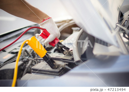 fixing car dead battery by jumping cables charge. 47213494