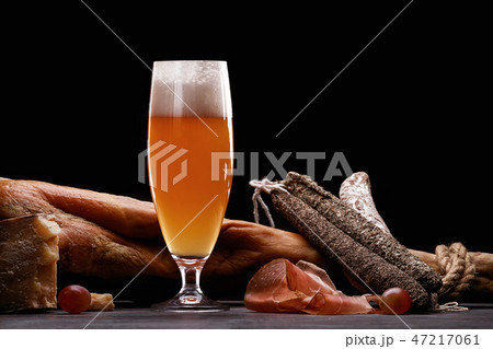 A glass of light beer foam, leg, Parma ham 47217061
