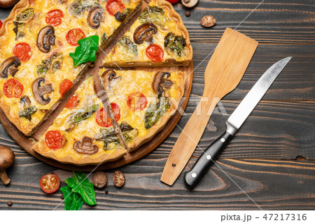 Traditional french Baked homemade quiche pie on wooden board Traditional french Baked homemade quiche pie on wooden board 47217316