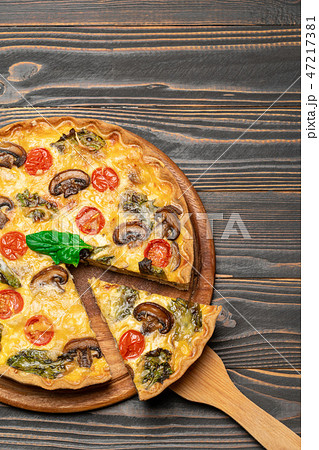 Traditional french Baked homemade quiche pie on wooden board Traditional french Baked homemade quiche pie on wooden board 47217381