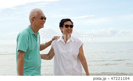 Asian senior couple walking together beach by sea Asian senior couple walking together beach by sea 47221104