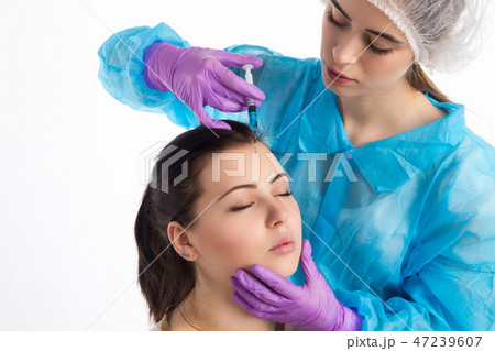 Doctor injects a botox Doctor injects a botox 47239607