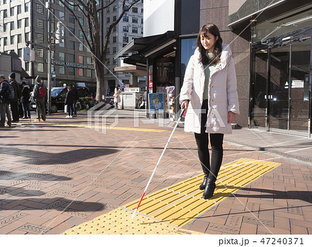 点字ブロックを歩く視覚障害者の女性 47240371