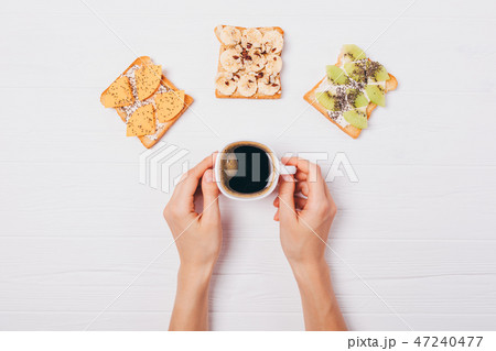 Woman's hands holding cup of coffee Woman's hands holding cup of coffee 47240477