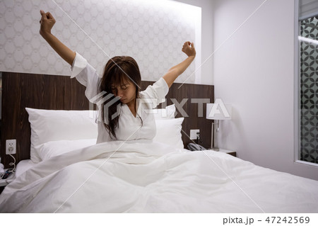asian young woman stretching on bed after waking asian young woman stretching on bed after waking 47242569