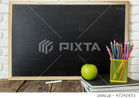 Books and chalkboard on wooden background 47242653