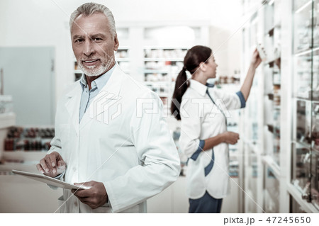 Bearded mature first-line pharmacist feeling joyful while working hard 47245650