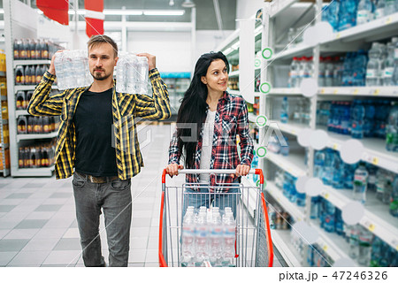 Couple buying mineral water in supermarket Couple buying mineral water in supermarket 47246326