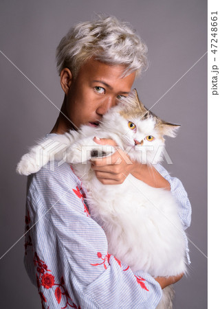 Young beautiful woman with short hair holding Persian cat Young beautiful woman with short hair holding Persian cat 47248661