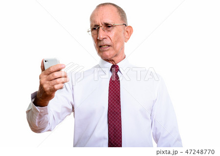 Studio shot of senior businessman holding mobile phone 47248770