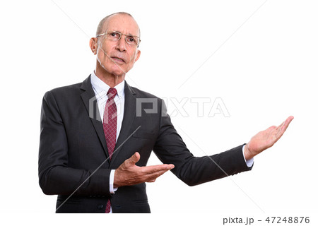 Studio shot of senior businessman showing something 47248876
