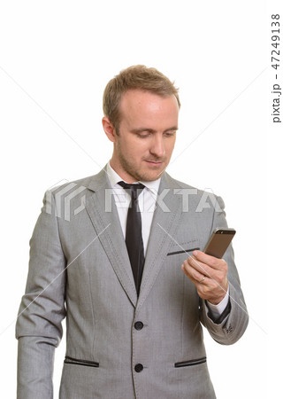 Handsome Caucasian businessman holding mobile phone isolated against white background 47249138