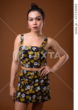 Young beautiful Asian transgender woman against brown background 47250060