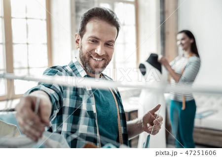 Helpful bearded husband helping his wife working as stylist 47251606