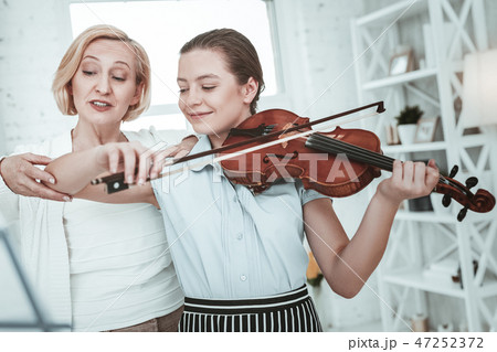 Nice pleasant woman holding her granddaughters arm 47252372