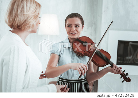 Positive nice girl looking at her music teacher Positive nice girl looking at her music teacher 47252429
