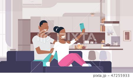 couple taking selfie photo on smart phone african american man woman sitting on couch young happy 47255933