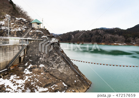 栗駒ダムとエメラルドグリーンの栗駒湖とダムフェンスと管理用ボート 栗駒ダムとエメラルドグリーンの栗駒湖とダムフェンスと管理用ボート 47257659