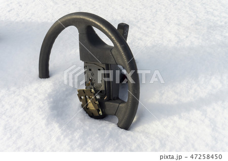 Steering wheel without airbag half buried in snow Steering wheel without airbag half buried in snow 47258450