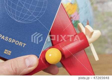 Passport and toy plane in hand Passport and toy plane in hand 47265648