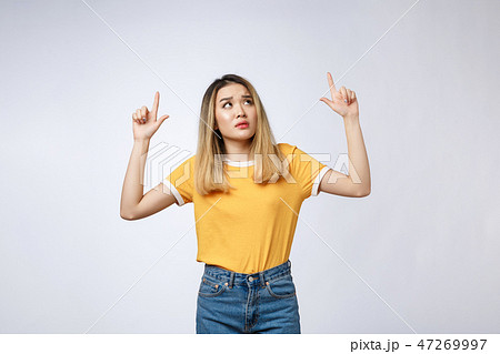 Young Asian woman looking angry and sad while pointing finger at camera isolated against white 47269997