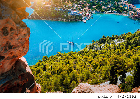 Epic view to blue bay of Assos village Kefalonia in warm morning sun light. White yacht at anchor in Epic view to blue bay of Assos village Kefalonia in warm morning sun light. White yacht at anchor in 47271192