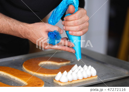 Close up view, hands of the chef with confectionery bag cream preparing a fiftie years old birthday 47272116