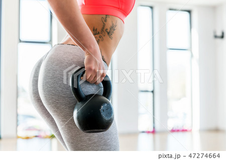 Fit woman holding a kettlebell. 47274664