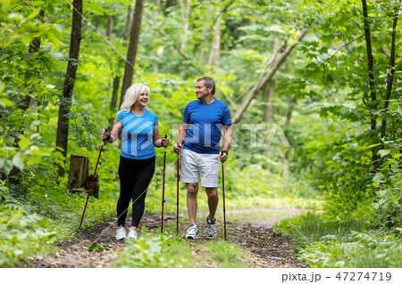 Elderly couple enjoying summer walk in the forest. Elderly couple enjoying summer walk in the forest. 47274719