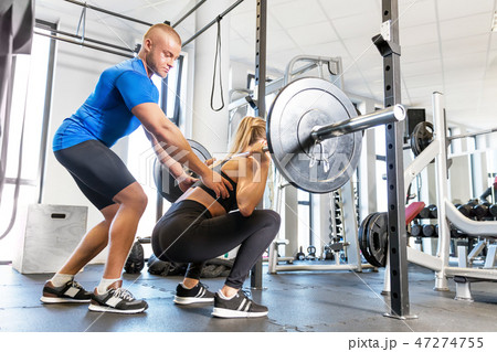 Personal trainer working with a client at the gym. Personal trainer working with a client at the gym. 47274755