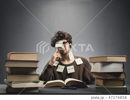 Man covered in sticky notes, studying. Man covered in sticky notes, studying. 47274858