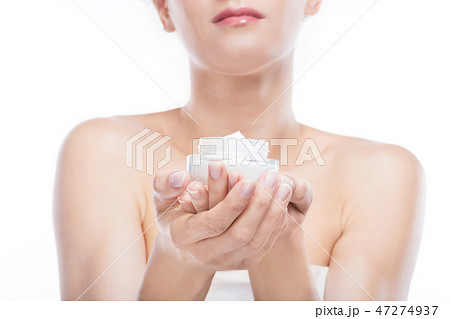 Young woman holding a moisturizer jar in her hands. 47274937