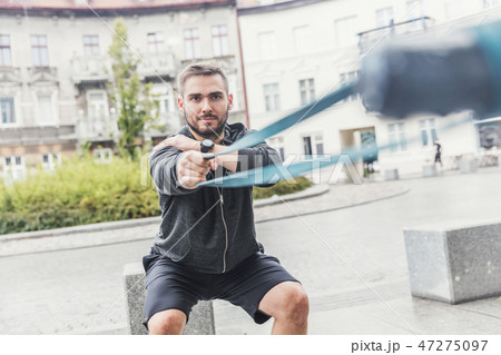 Man strengthening his arms in the city. 47275097