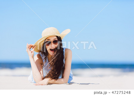 Young enthusiastic girl laying on the beach, smiling. Young enthusiastic girl laying on the beach, smiling. 47275248