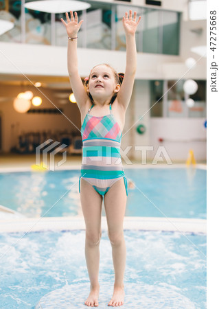 Little girl standing on the floor in a pool 47275668