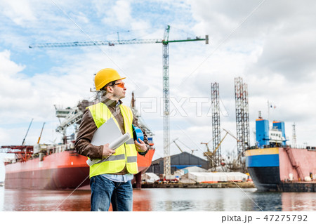 Shipbuilding engineer at the dock side in a port. Shipbuilding engineer at the dock side in a port. 47275792