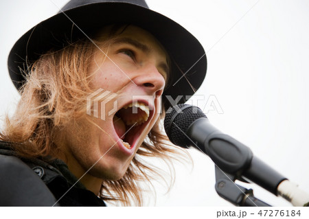Young man sings to microphone Young man sings to microphone 47276184