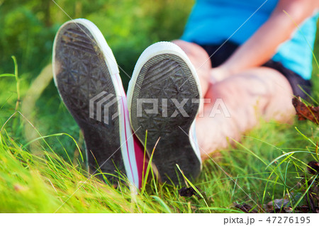 Pink sneakers on girl legs on grass Pink sneakers on girl legs on grass 47276195