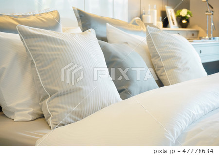 Closeup roll of pillows setting on comfortable bed 47278634