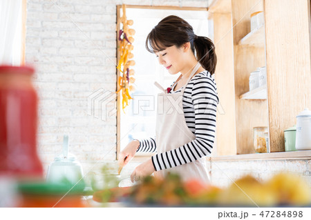 朝ごはんを作る女性 料理をする主婦 キッチン 台所の写真素材