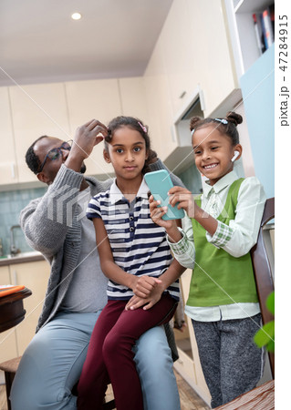 Cute daughter feeling amazed while playing game on smartphone 47284915