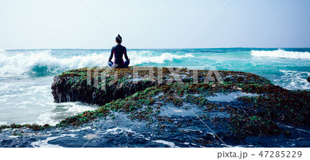 Woman meditation at the seaside croal cliff edge  47285229