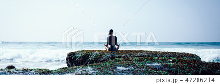 Woman meditation at the seaside croal cliff edge  47286214