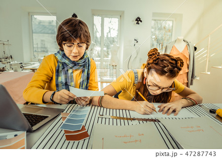 Girl drawing sketches while working in atelier with friend Girl drawing sketches while working in atelier with friend 47287743