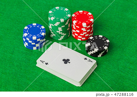 Casino chips and playing cards on green table 47288116