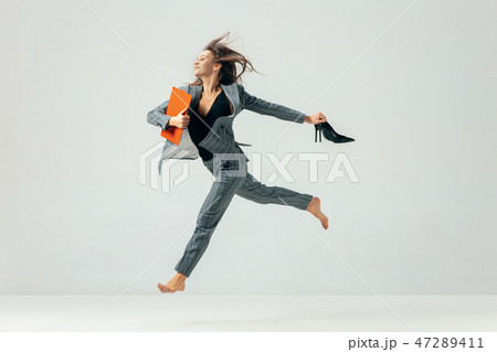 Happy business woman dancing and smiling isolated over white. Happy business woman dancing and smiling isolated over white. 47289411