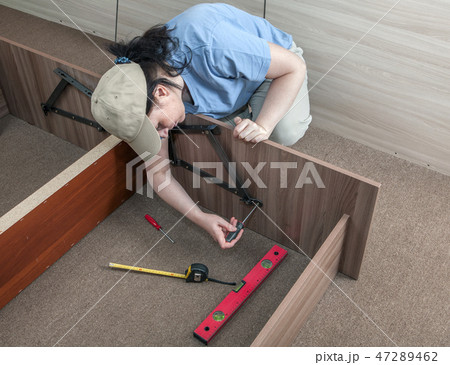 Women putting together self assembly furniture. 47289462