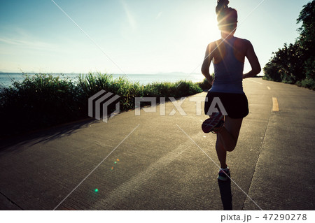 woman running on seaside trail in the morning woman running on seaside trail in the morning 47290278